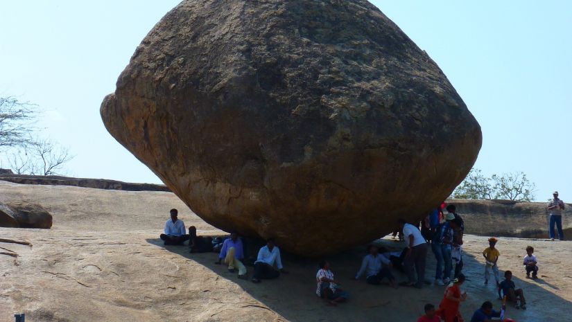 Giant rock balanced on a slope with the blue sky in the background