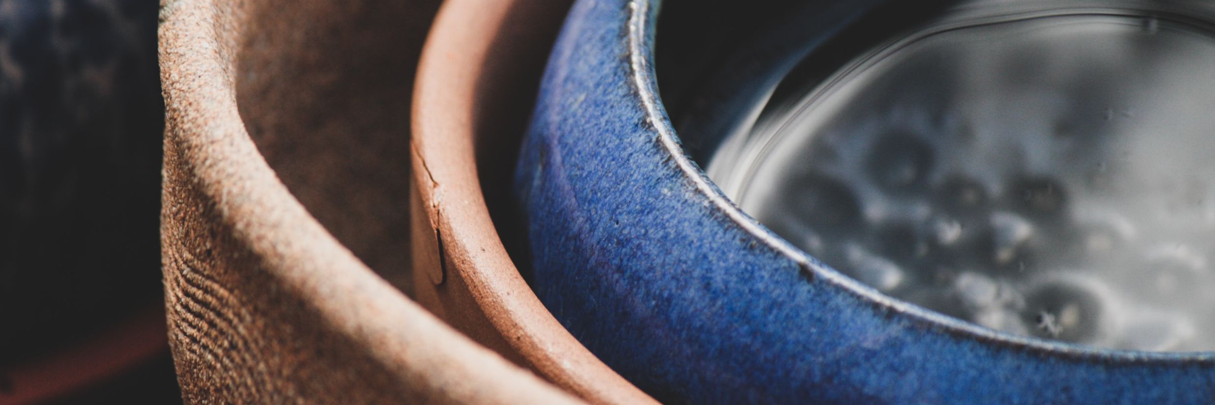 three Pots kept inside each other with two pots being brown and the last one being blue