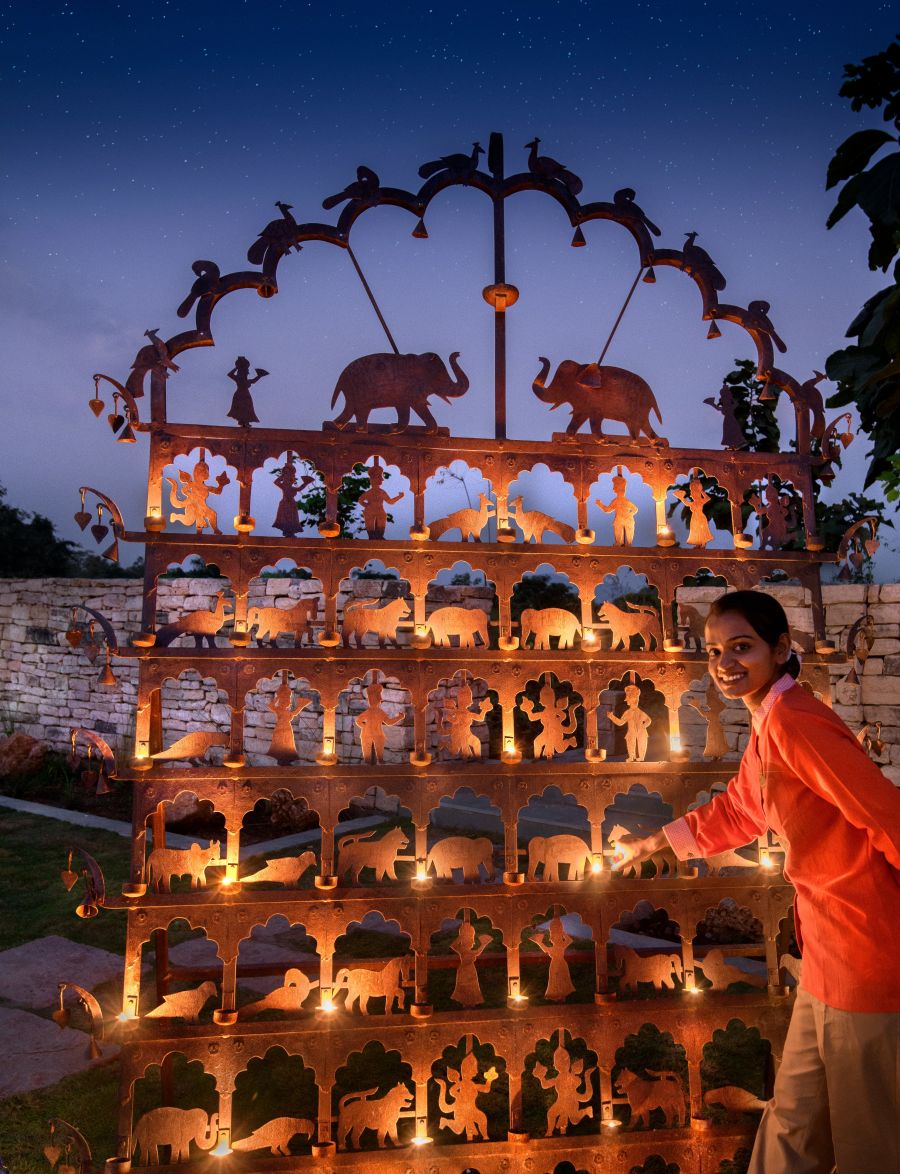 Woman Litting Diyas on a Prop Wall