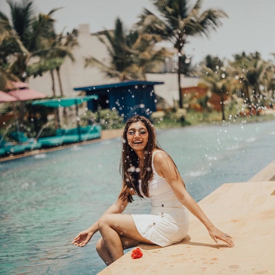 Woman in white dress enjoying by the pool at our South Goa resort