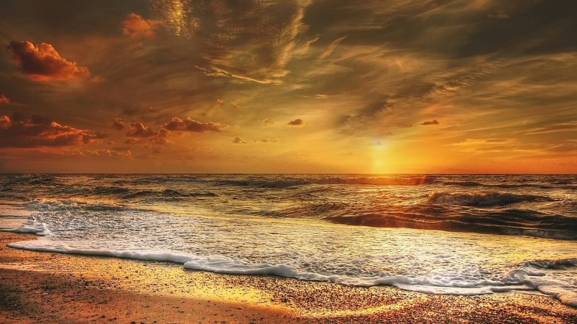 sun setting on the horizon at a beach