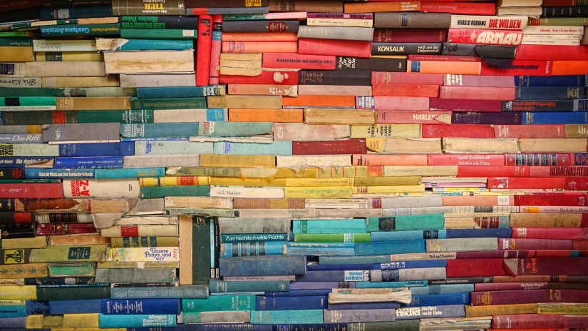 a close up image of Multiple stacks of colourful books