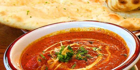 a plate served butter chicken and naan