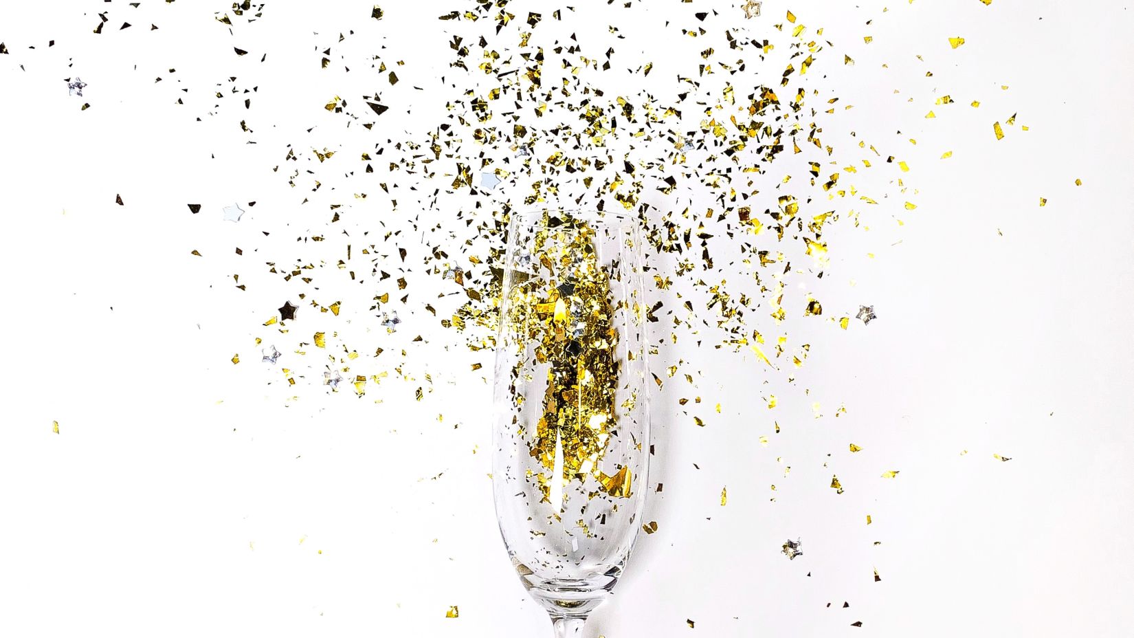 a campagne glass with glitter being blown from it