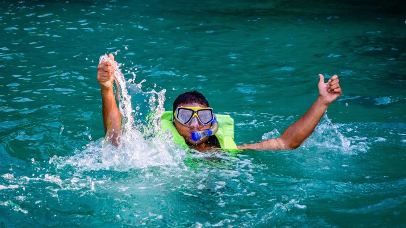 a person showing double thumbs up while snorkelling