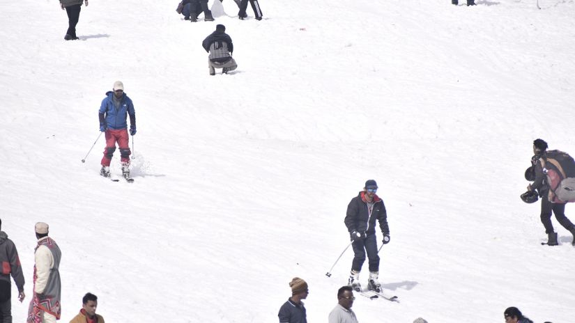 A bunch of people are skiing down a snow-covered slope.