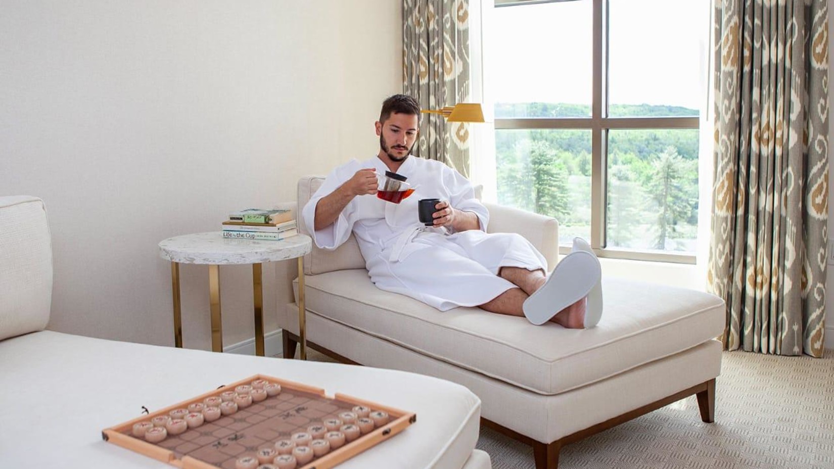 Yo1 Longevity and Health Resorts - Image of a man in a white shirt relaxing on a sofa