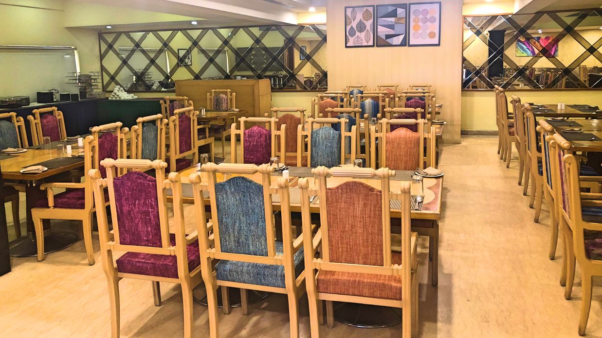 seating arrangments inside a restaurant with the lights switched on - Raj Park Hotel, Tirupati