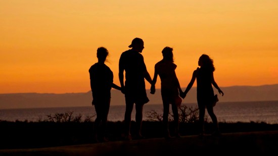 silhouette of a family holding hands