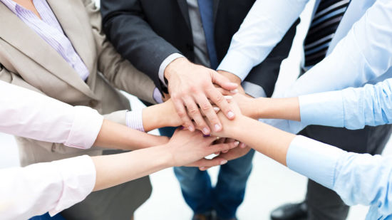 a group of people keeping their hands on each other