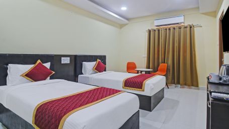 A hotel bedroom highlighting the twin beds, tea & coffee maker, and the room's minimalistic style and clean lines.