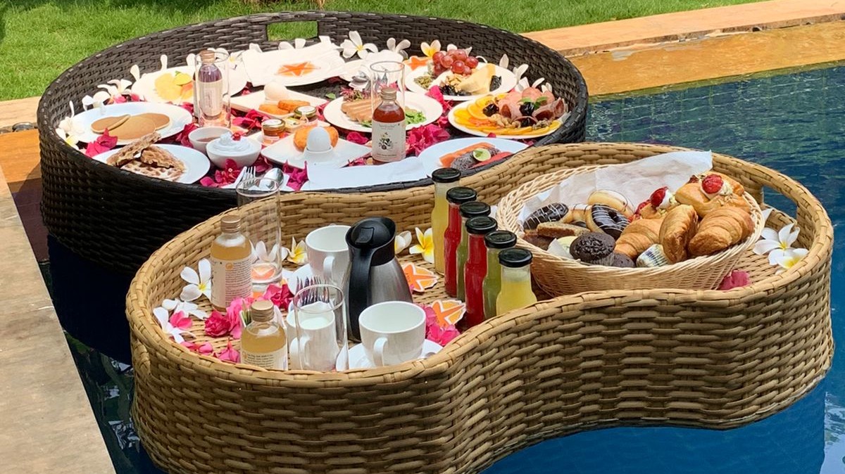 Two baskets of floating breakfast on a pool