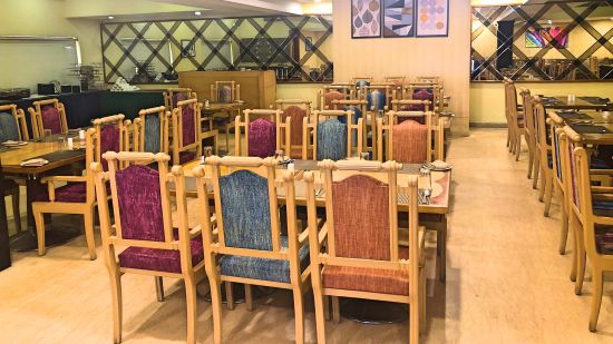 seating arrangments inside a restaurant with the lights switched on - Raj Park Hotel, Tirupati