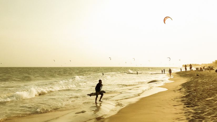 corner view of a beach with a group of people indulging in water sport activities