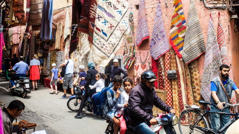 a local indian market filled with locals travelling in bikes and cycles, captured during the day @ Lamrin Norwood Green, Palampur