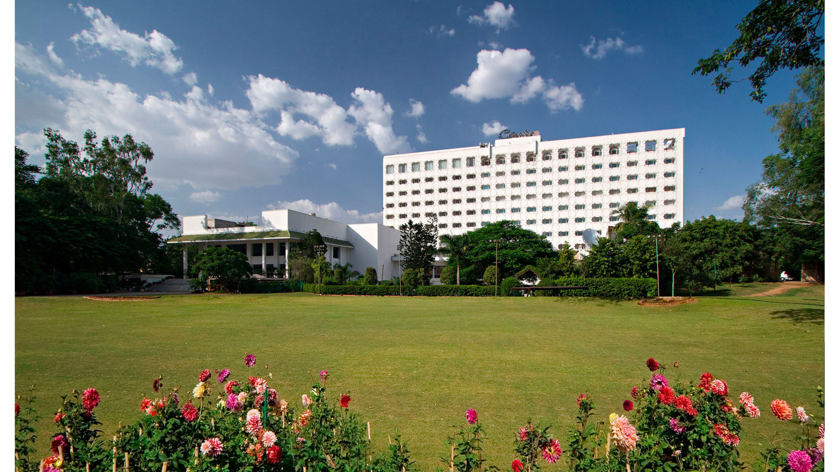 A panorama of the facade and the green lawn of Hotel Clarks Amer