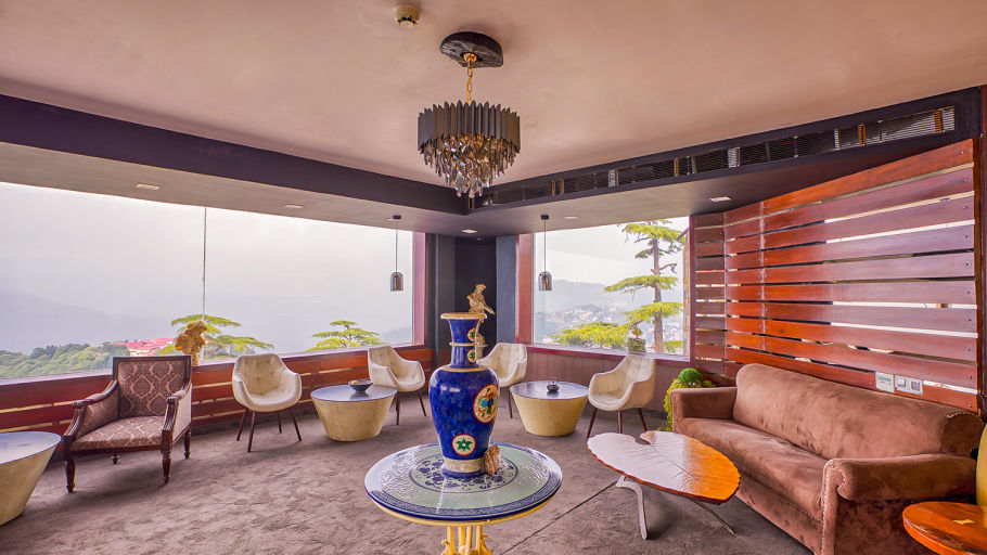 Tea lounge with aesthetic couches and seating arrangement that captures the outside view of mountains - Renest Dunsvirk Court Mussoorie