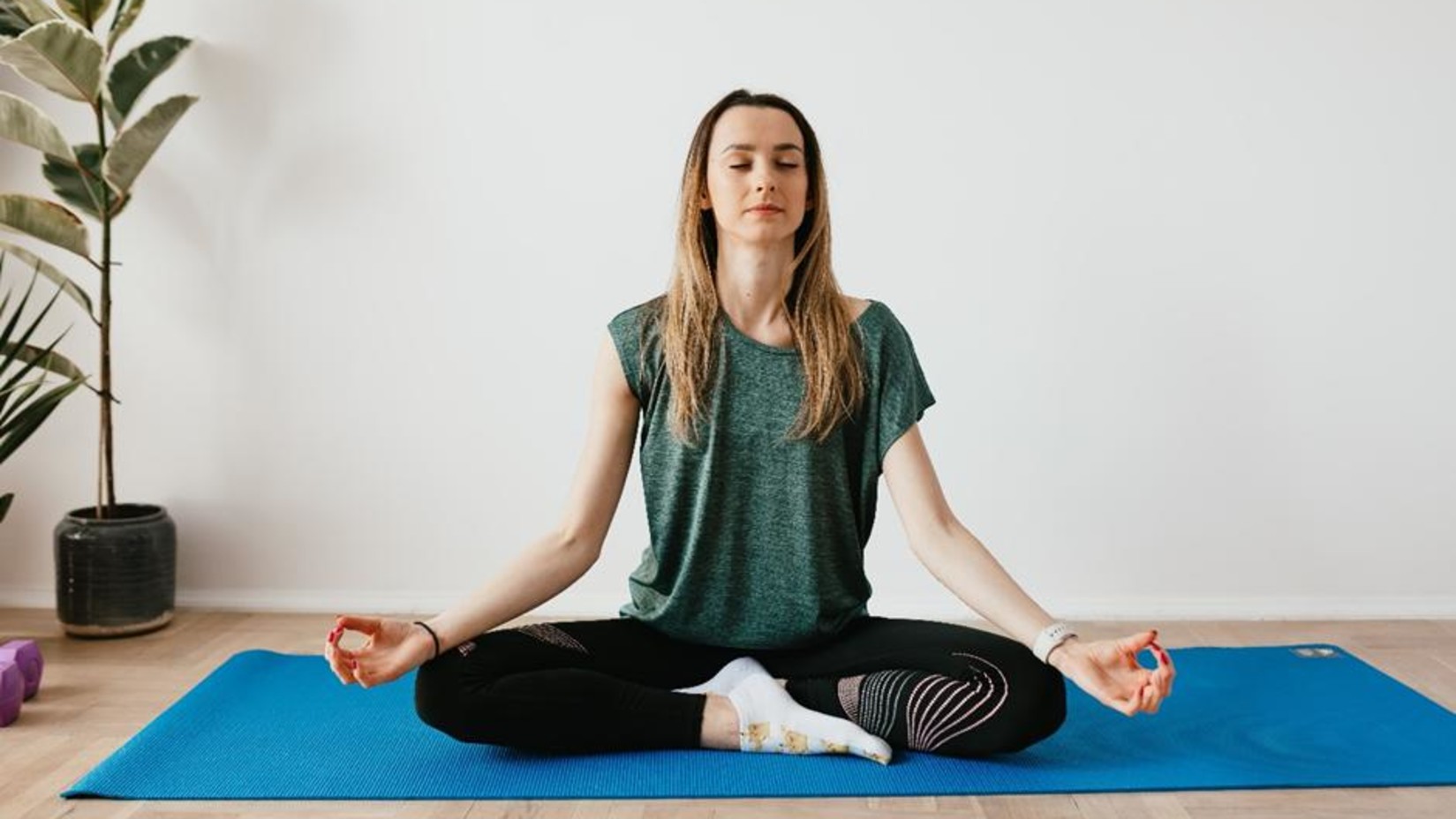 a woman meditating on a yoga mat