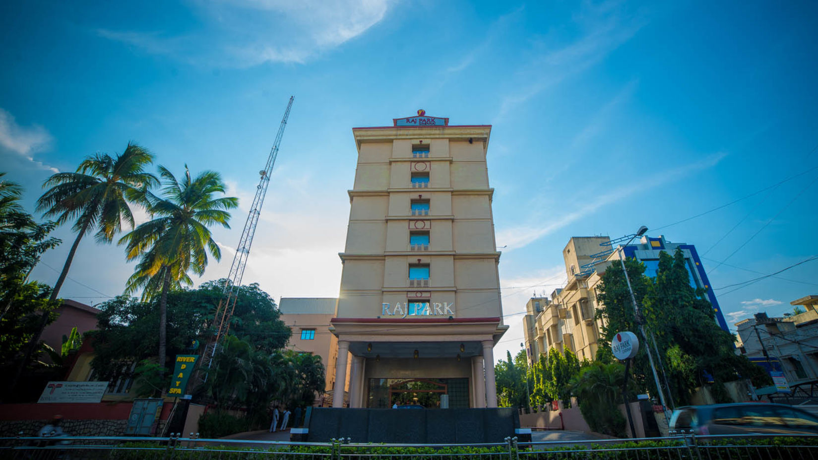 facade view of Raj Park Hotel in Alwarpet with blue sky in the background