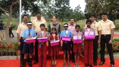 Adults and children standing with prizes