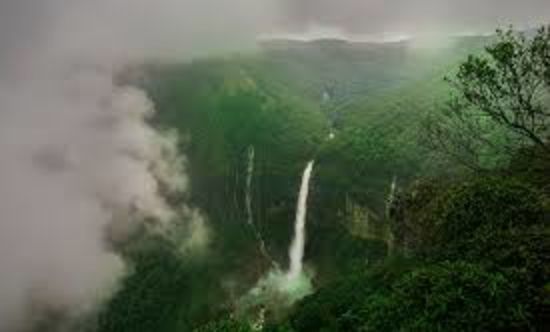 alt-text an aerial view of a hill station with a waterfall and clouds floating by