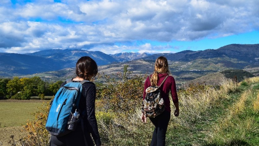 two women trekking on a hill