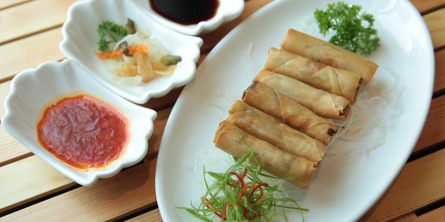 spring rolls served on a plate with sauces