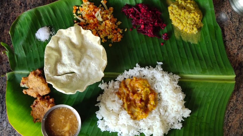 a banana leaf with a south indian meal spread