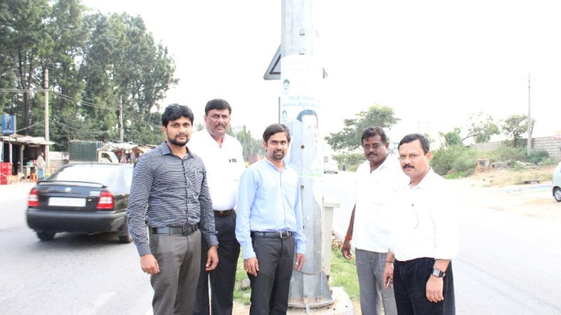 People standing on a road divider beneath a streetlight