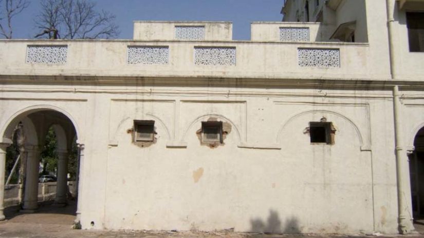 a broken window on the outer building in the ground floor tiles lines up on the floor with columns on the side and background - The Baradari Palace