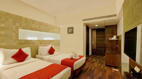 the twin beds facing the TV offered at the executive room - Monarch Luxur Hotel, Bangalore