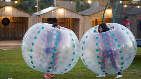 two people playing in Zorbing Balls at Themis Mudhouse - A Nature