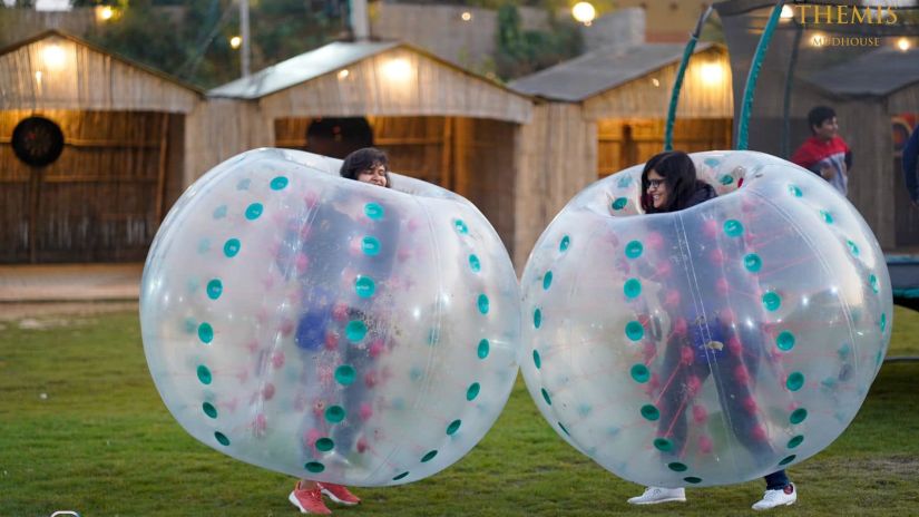 two people playing in Zorbing Balls at Themis Mudhouse - A Nature's Retreat Resort & Wellness