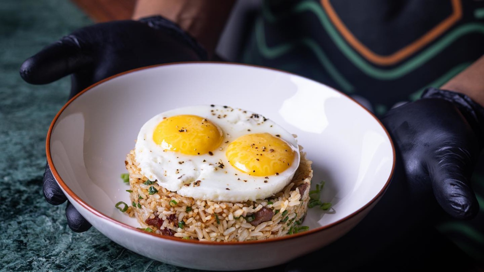 A person stands beside a bowl of bullseye and rice - Villa in Palms by V Escapes