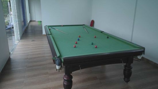 a close-up shot of a Snooker table with cue ball and other coloured balls kept on the table