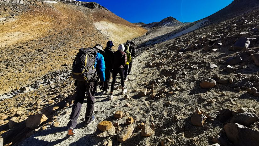 a group of people hiking in a mountain terrain with their backpacks