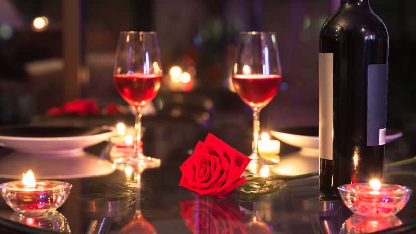 two wine glasses kept on a table along with a bottle of wine