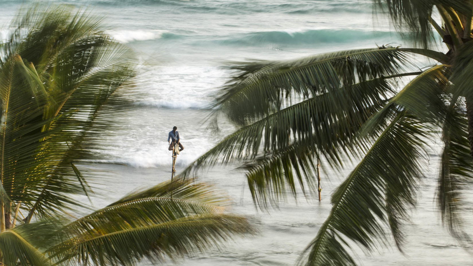 person fishing on stilts in the background