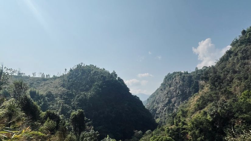 a trail during Mawryngkhang Trek with mountain in view and blue sky in the background