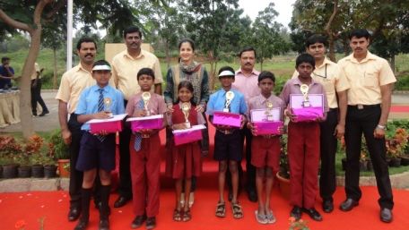 Adults and children standing with prizes