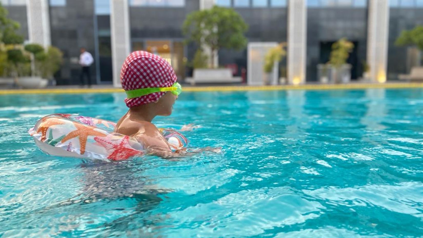 a child playing in swimming pool with a float