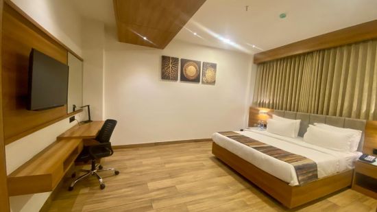 suite at Comfort Resort, Morbi arrayed with a bed, television, air-conditioning