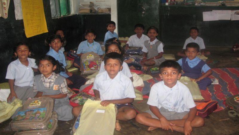 Students sitting in classroom with their backpacks