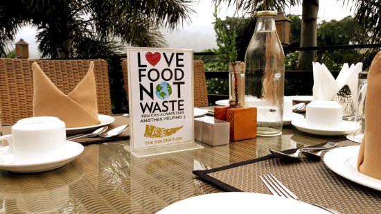 A small board with recycling words on the table of a restaurant at Golden Tusk