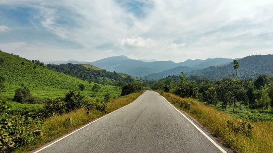 an empty road leading to mountains