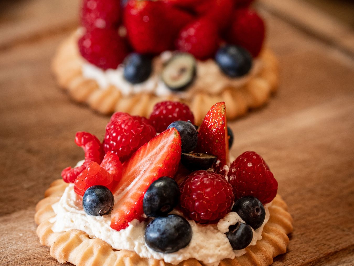 a tart with whipped cream and assorted berries on top