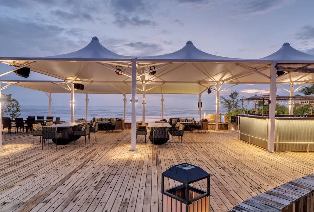 an outside cabana seating arrangement overlooking the beach - Mayfair On Sea, Morjim, Goa