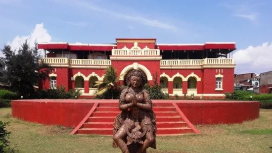 a red coloured temple with a goddess statue at the front