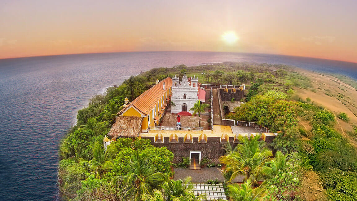 Birds eye view of a church inside a fort on an island with many trees