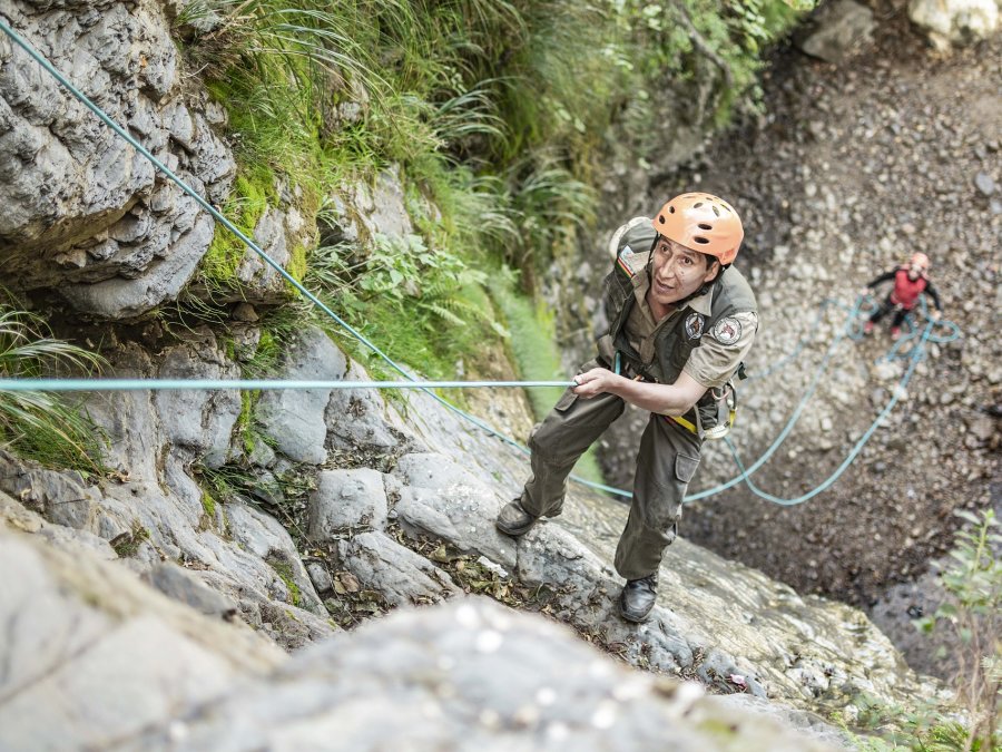 a person rappelling down the steep slopes